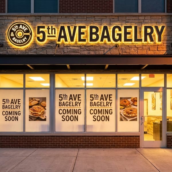 Exterior of 5th AVE BAGELRY with an illuminated sign and "Coming Soon" window posters featuring bagels.
